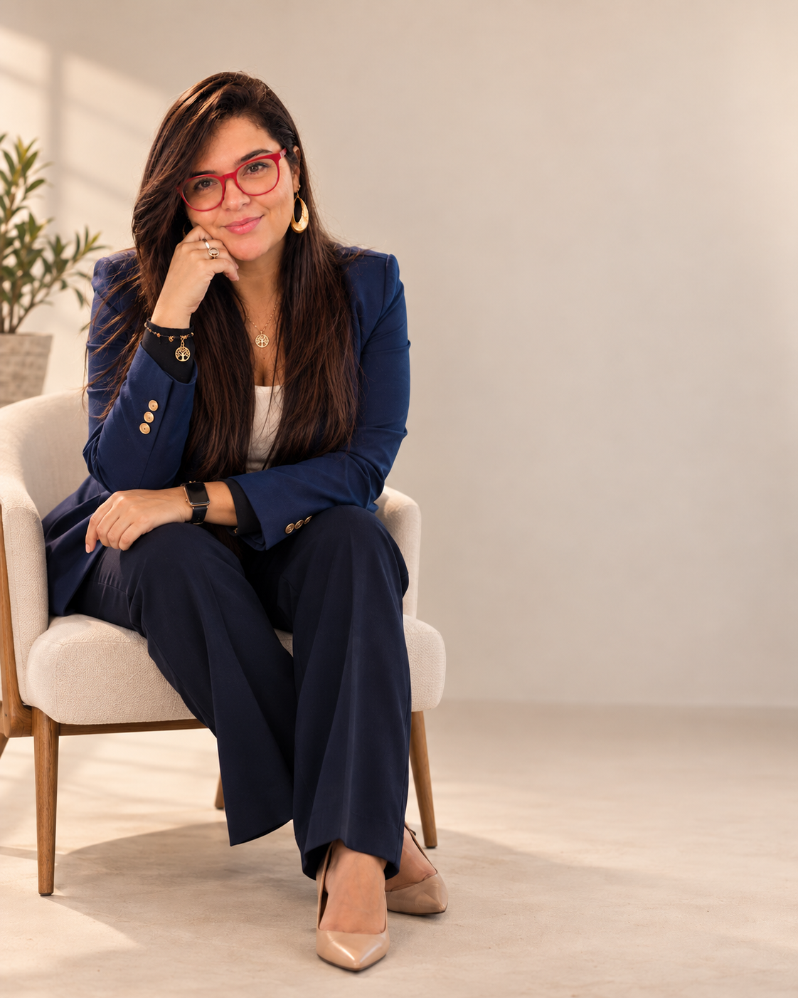 Grace Lopes sentada, com blazer azul, em um ambiente claro